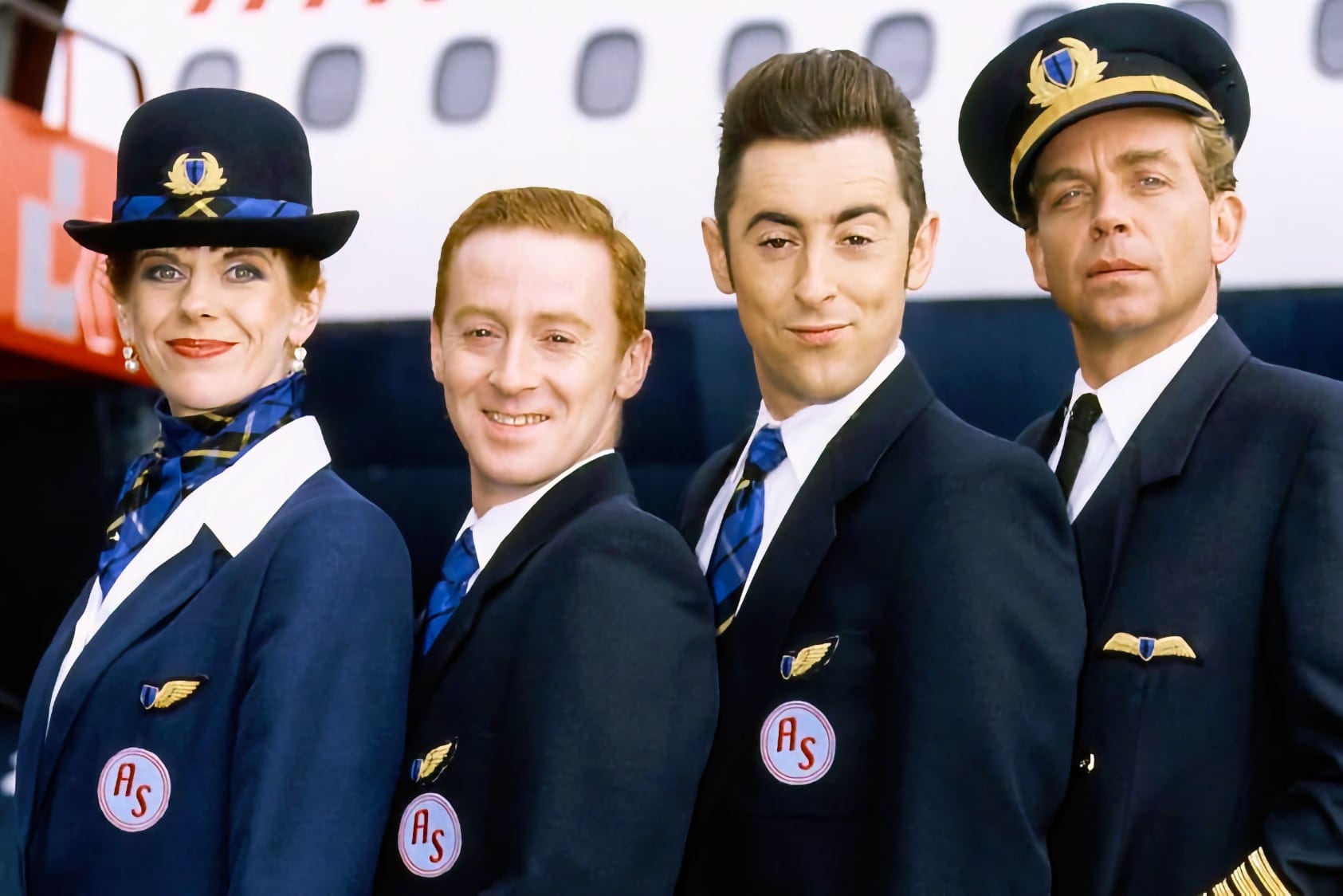 Four cast members in Air Scotia uniforms pose in front of an aircraft