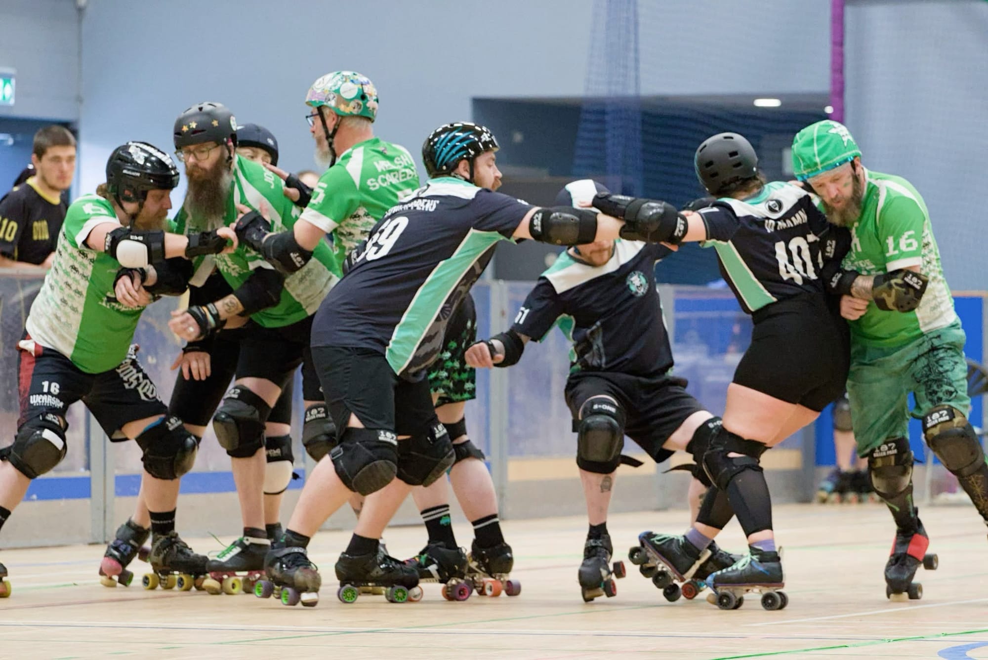 Roller derby players blocking and pushing during a bout, wearing helmets and pads