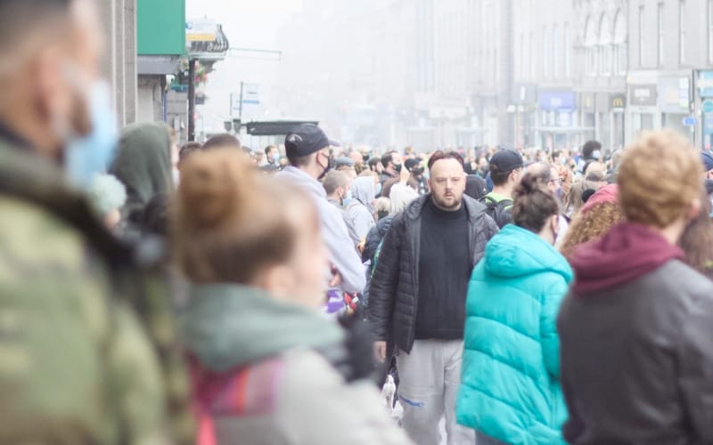 A large crowd fills an Aberdeen city centre street on a misty day.