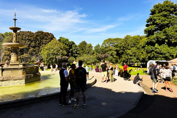 People gather near the granite fountain in Victoria Park, featured in the new family-friendly walking trail.