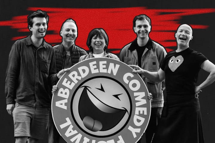 The five comedians holding Aberdeen Comedy Festival sign, smiling in front of bold red and black backdrop.