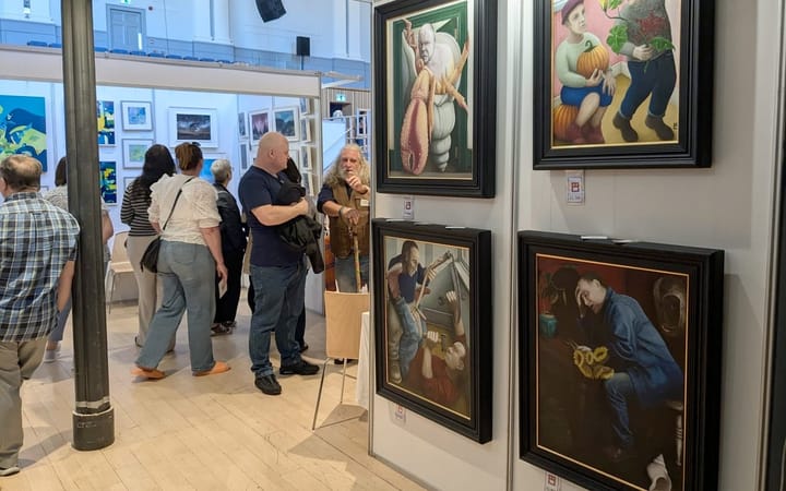 Visitors browse framed paintings at Aberdeen Art Fair inside the Music Hall