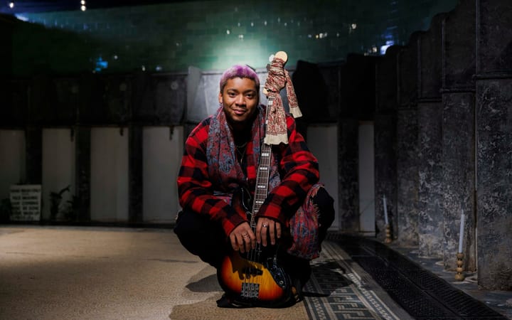 Nuna Mutikani with bass guitar inside the Victorian Toilets, Union Terrace Gardens.